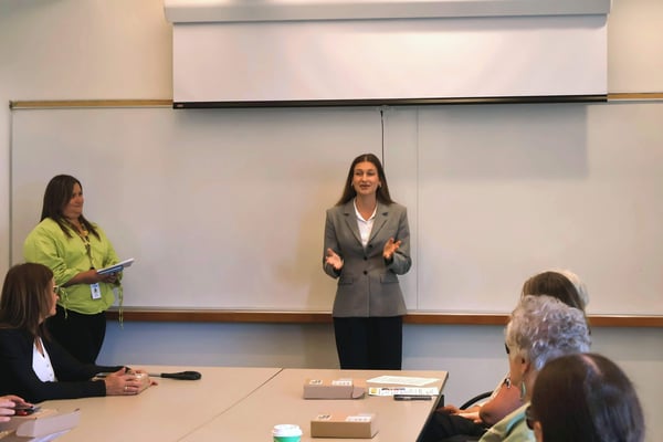 A Valet Wireless team member speaks and gestures while presenting to seated participants in a conference room.