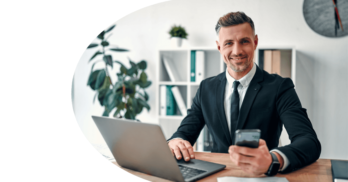 man in a suit with a phone and a laptop